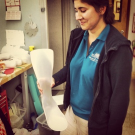 Clare shows a custom solid ankle-foot orthoses she fabricated using a vacuum form technique at the clinic.